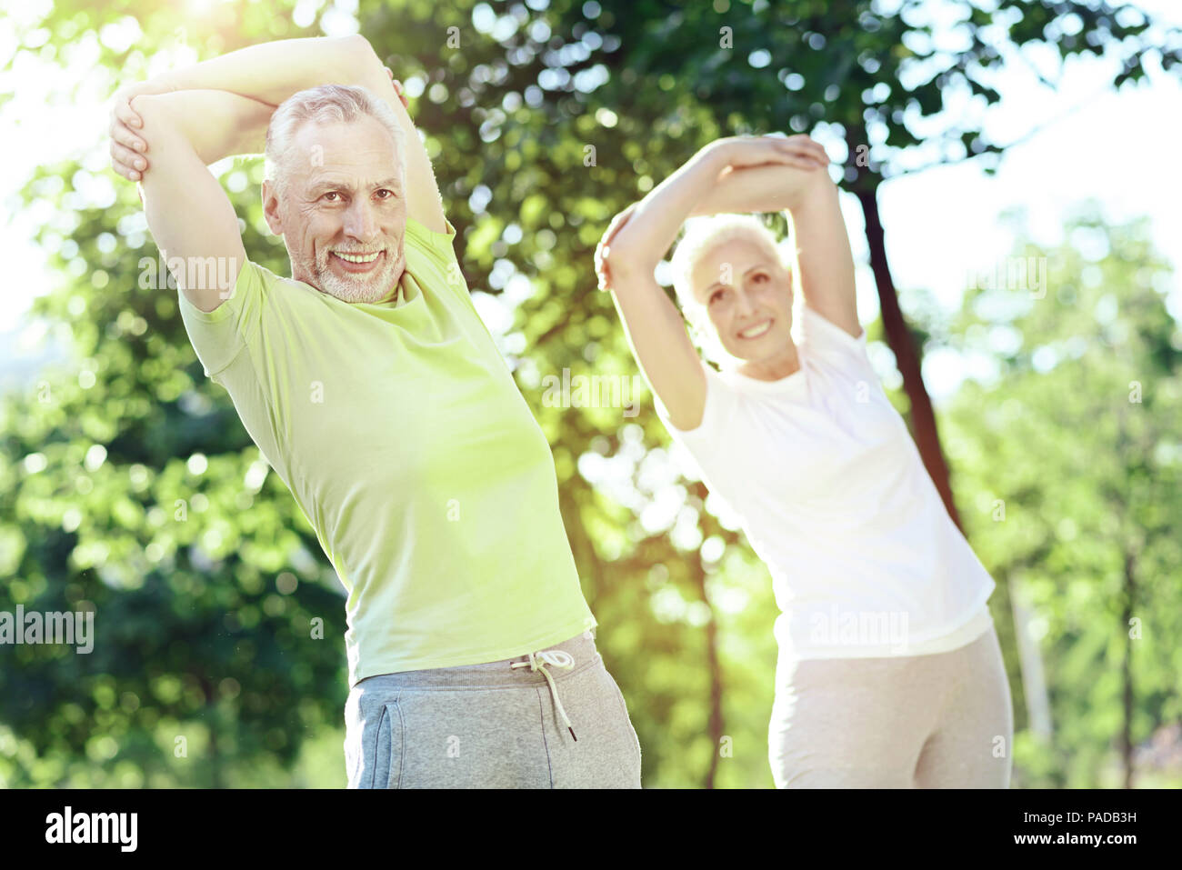 Pleasant aged couple looking happy while training Stock Photo