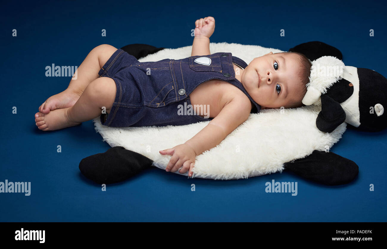 Baby in costume lay on pillow in studio background Stock Photo Alamy