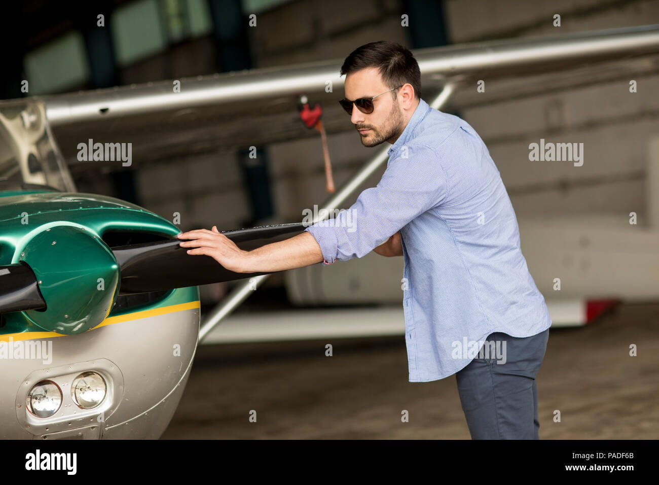 Handsome young pilot checking ultralight airplane before flight Stock Photo