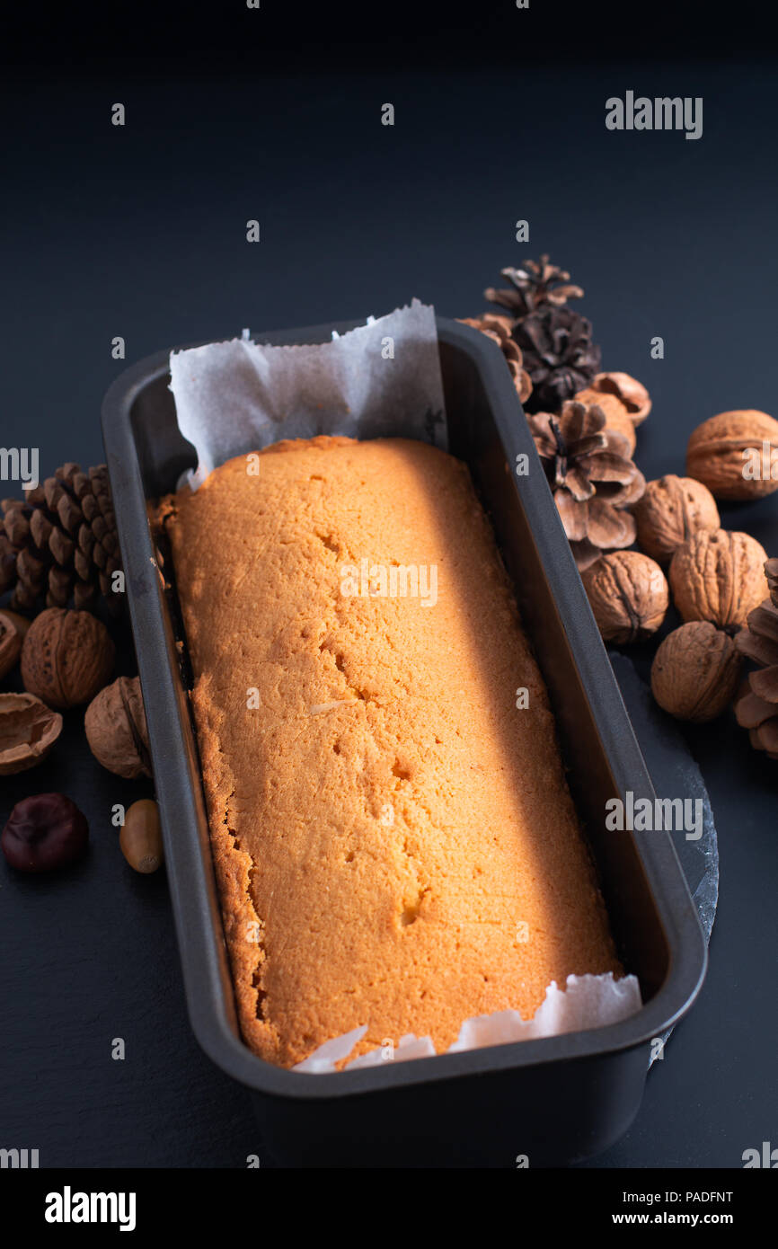 Fresh baked homemade pound, butter cake in loaf pan on slate stone plate  decor by pinecorn and walnuts Stock Photo - Alamy