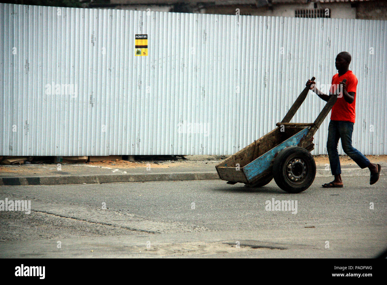 African man pushing his hand cart towards the market in Abidjan, Cote d'Ivoire Stock Photo