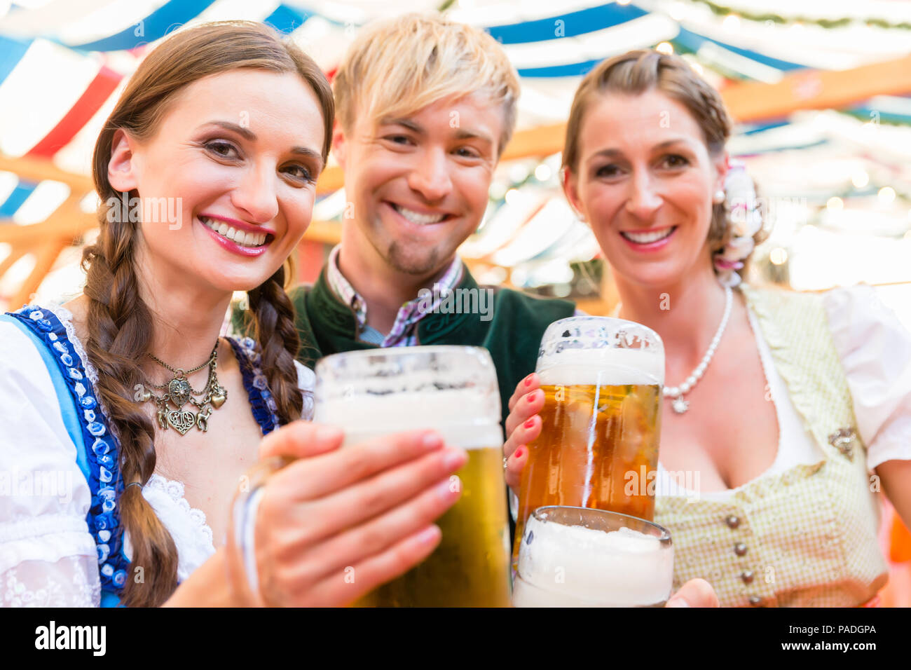 Friends with beer glasses at Bavarian beer tent Stock Photo