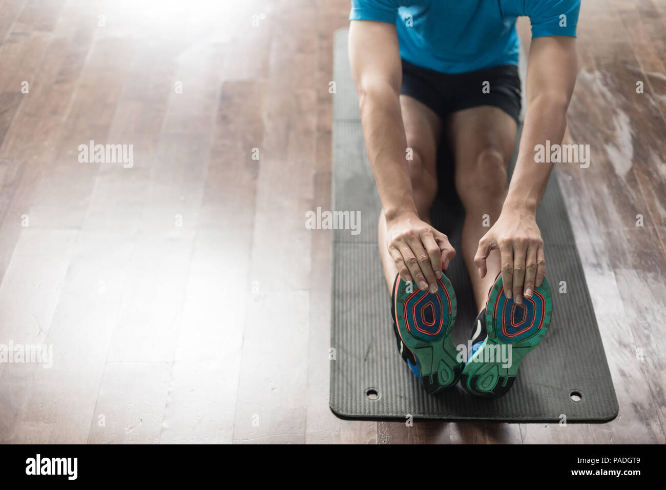 High-angle view of the hands of a man touching his toes as a stretching exercise Stock Photo