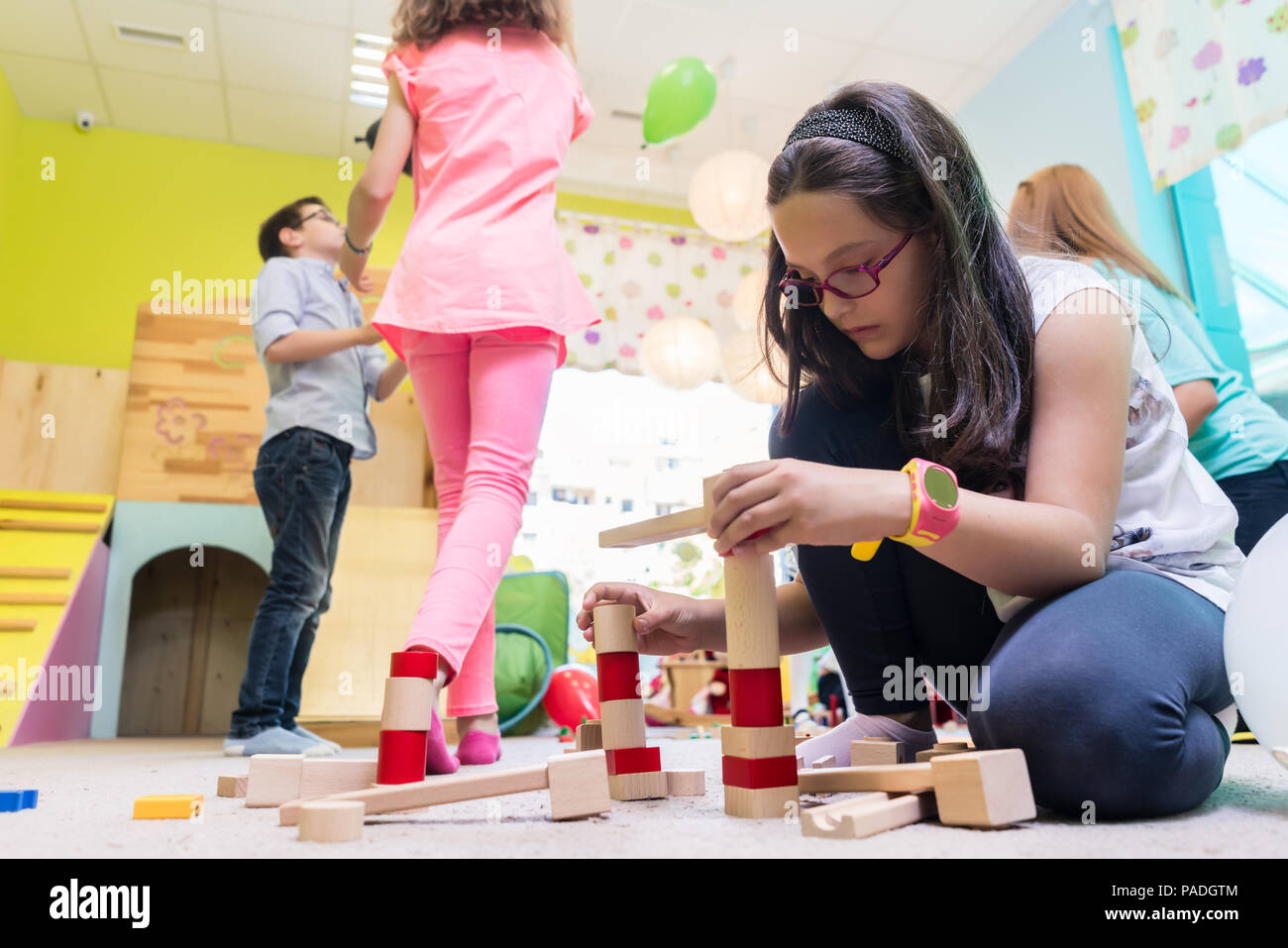 Cute girl building a structure in balance during playtime at the kindergarten Stock Photo