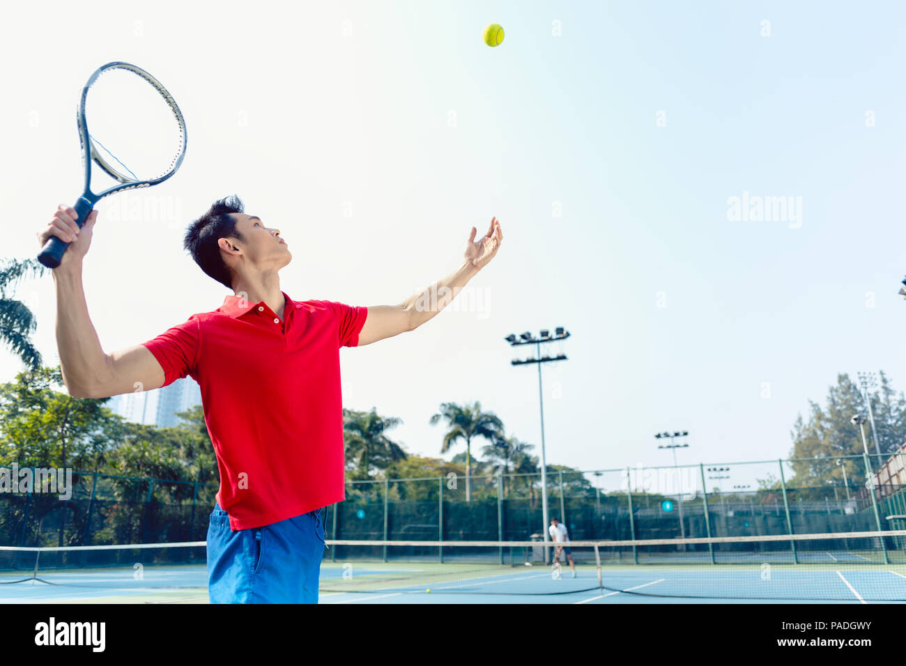 Chinese tennis player ready to hit the ball while serving Stock Photo