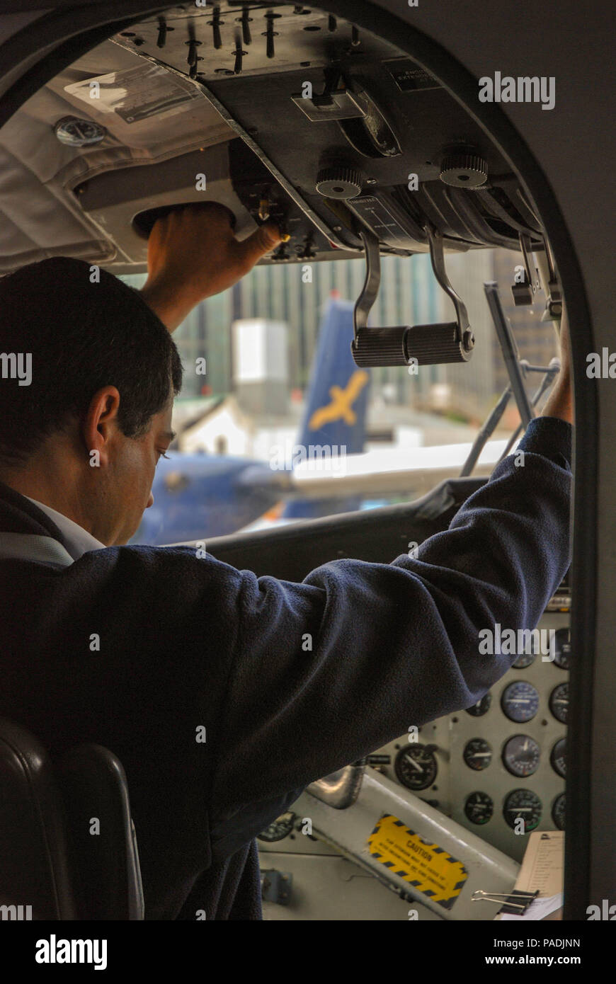 Pilot operating the throttle control of a Twin Otter float plane on its ...
