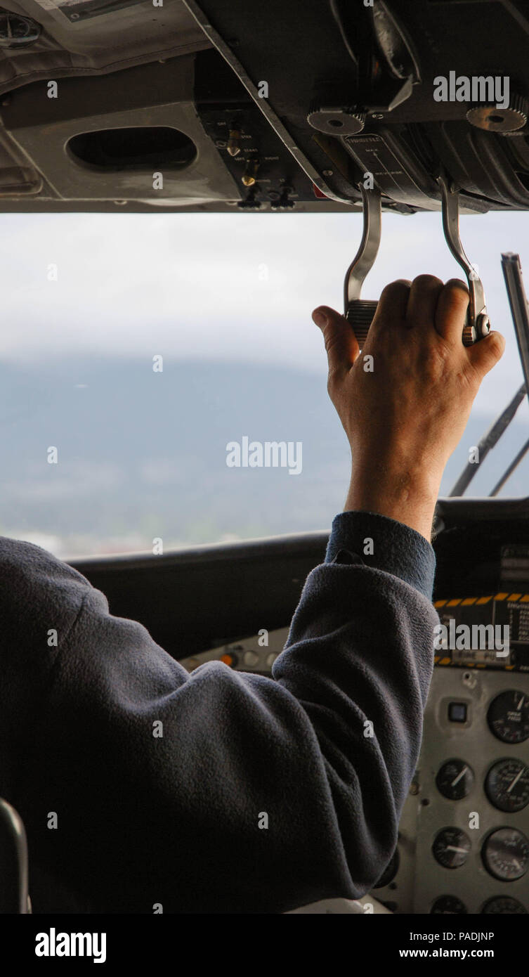 Pilot operating the throttle control of a Twin Otter float plane on its ...