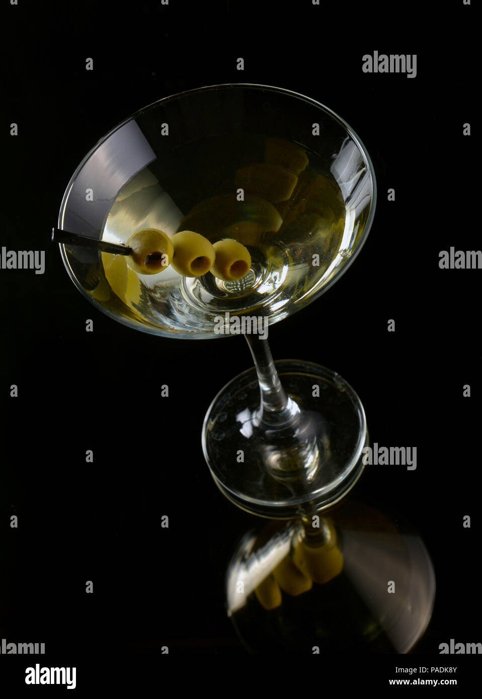 Martini with olives on a black background Stock Photo - Alamy