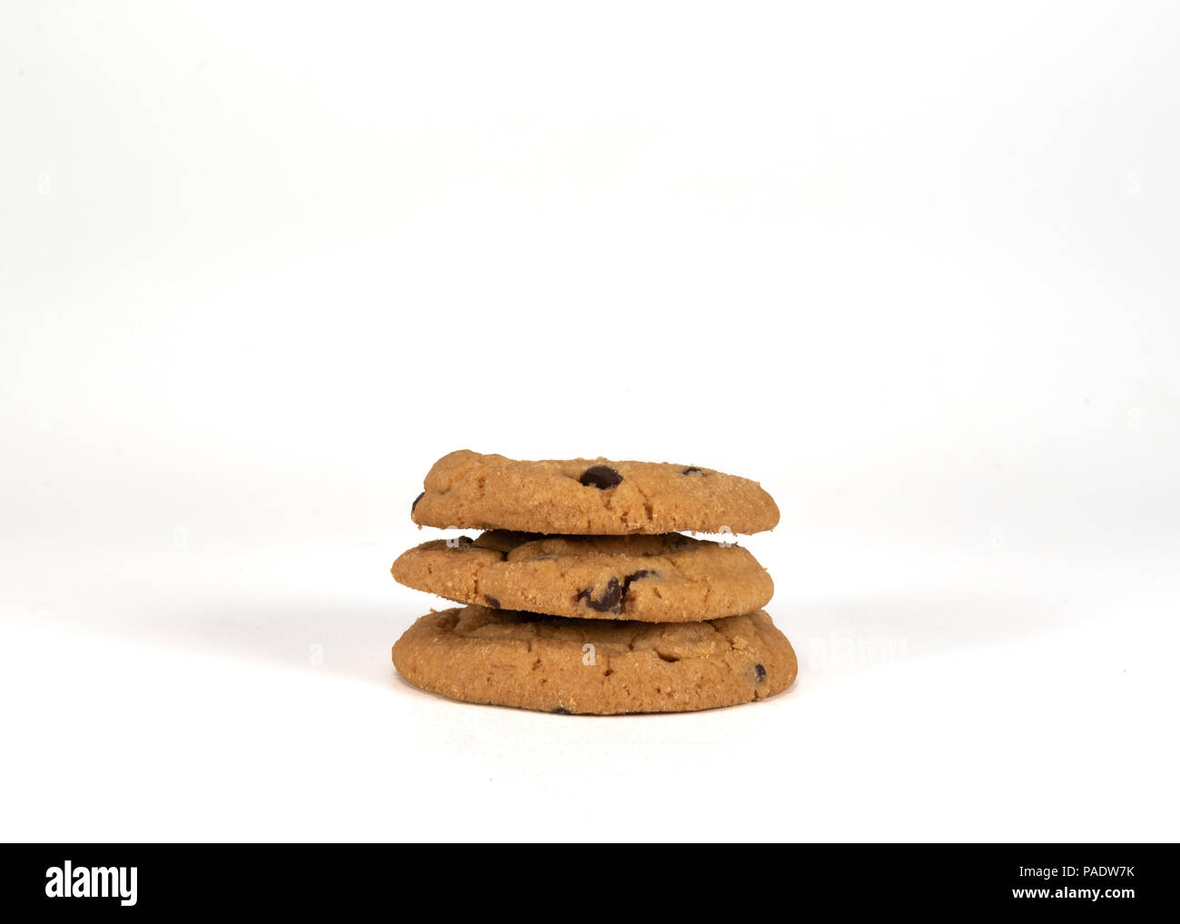 Three Stacked Chocolate Chip Cookies on White Background Stock Photo