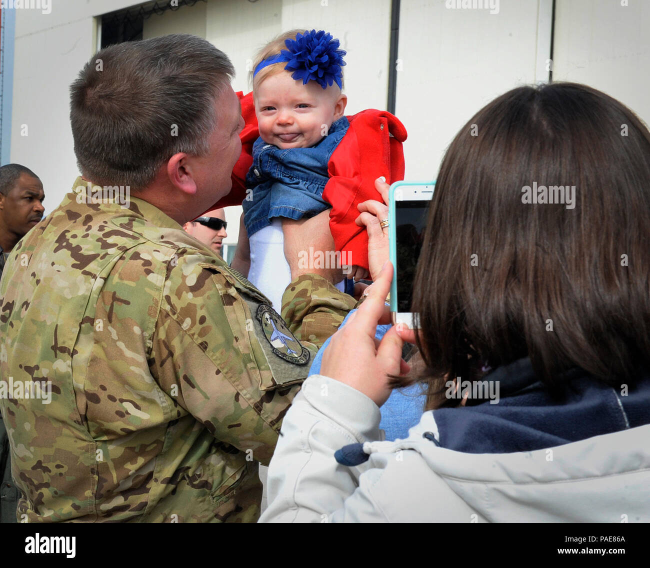 Maj. Thomas Chapman, 76th Airlift Squadron chief of training, holds his daughter after returning from a deployment March 15, 2016, at Ramstein Air Base, Germany. Spouses, children, friends and coworkers welcomed the Airmen home and thanked them for their commitment, sacrifice and dedication to the mission. (U.S. Air Force photo/Airman 1st Class Larissa Greatwood) Stock Photo