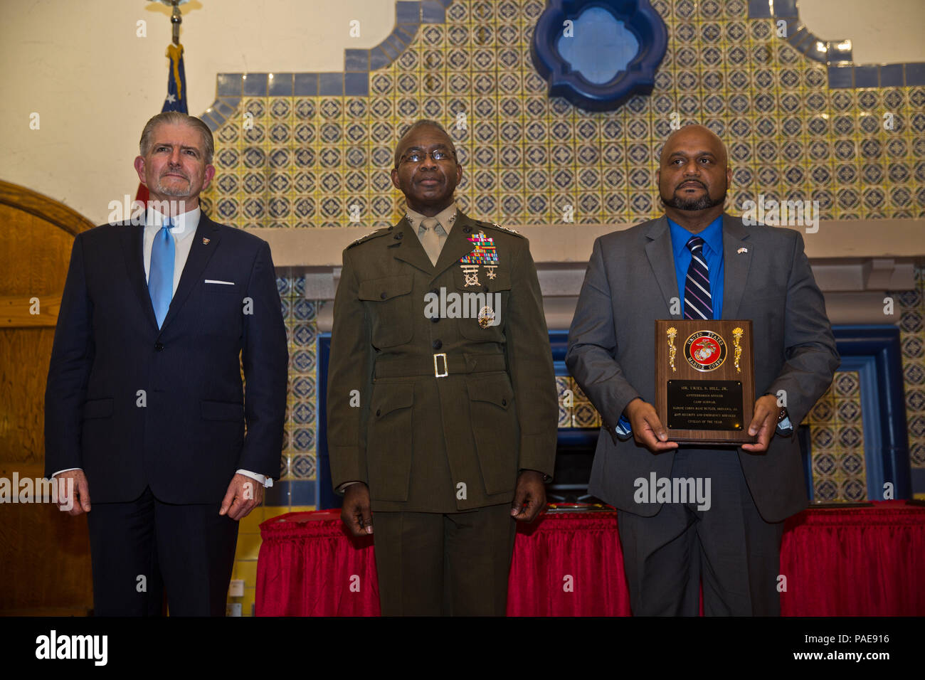 Mr. Uriel S. Hill, Jr., right, an anti-terrorism officer at Marine Corps Base Camp Butler, Camp Schwab, Okinawa, Japan, poses for a photograph with Lt. Gen. Ronald Bailey, center, Deputy Commandant Plans, Policies, and Operations, and Mr. Randy Smith, Assistant Deputy Commandant Plans, Policies, and Operations, during a ceremony held at Marine Corps Recruit Depot San Diego, Calif., March 8, 2016. Hill was recognized for making a positive change in his command by improving work flow. (U.S. Marine Corps photo by Lance Cpl. Robert G. Gavaldon/Released) Stock Photo