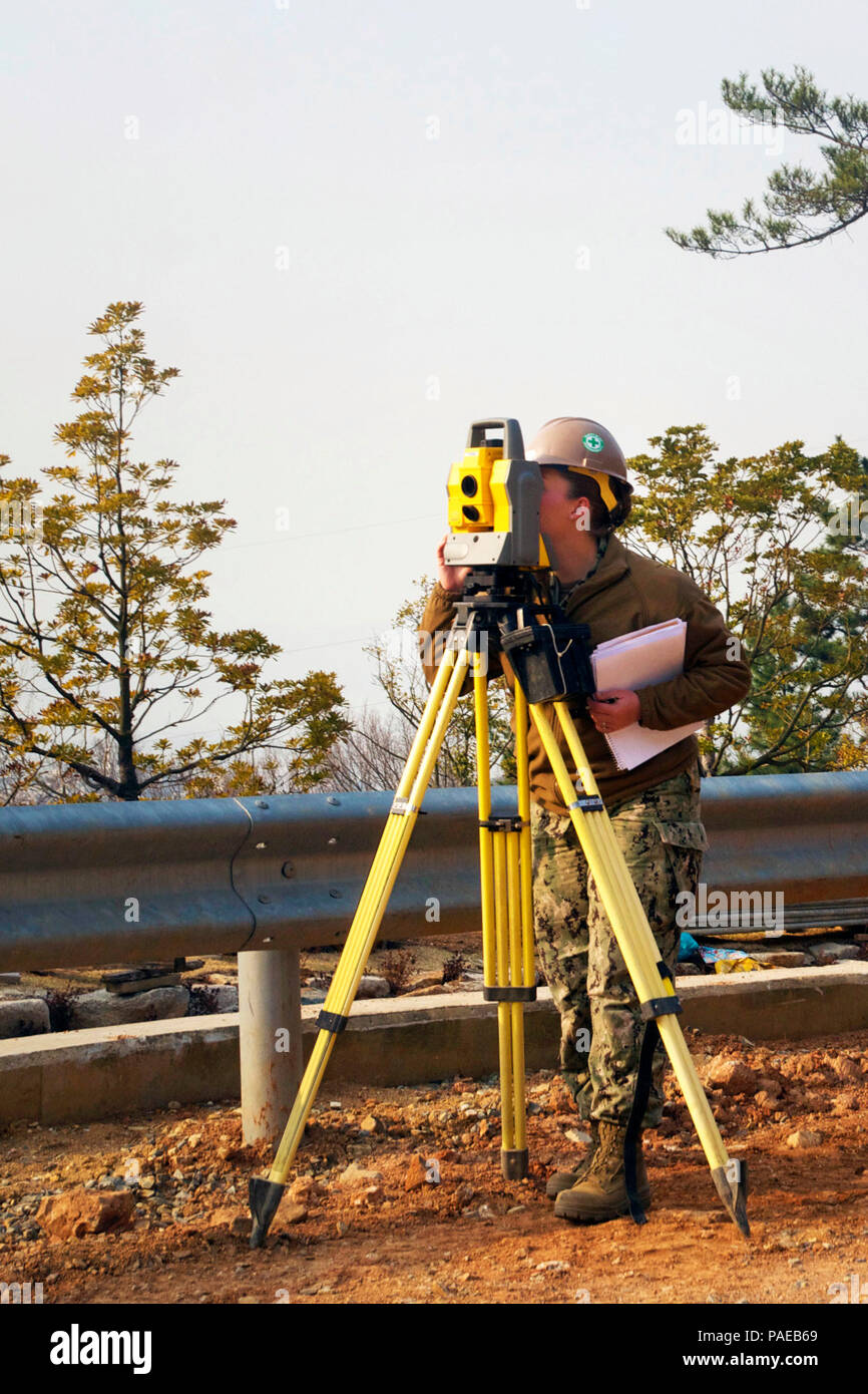 160323-N-NE195-008  CHINHAE, Republic of Korea (Mar. 23, 2016) - Taking a peak into the sights of a Trimble 5000 series geode meter, Engineering Aid Constructionman Alexis Chamot shoots elevation measurements for the topographical survey for the initial design of a storage lot on the US Naval Chinhae Facility during the 2016 Foal Eagle exercise.  Recording topographical information is a construction process necessary to accurately plan and estimate for everything from, materials, design layout, to how many crew members are essential to complete the project.  (U.S. Navy photo by Utilitiesman 3r Stock Photo