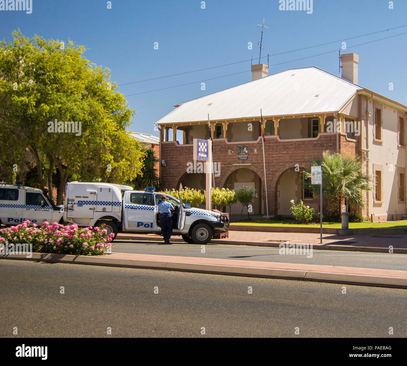 Police station and cars, with uniformed policewoman  in the city of Broken Hill, New South Wales, Australia Stock Photo