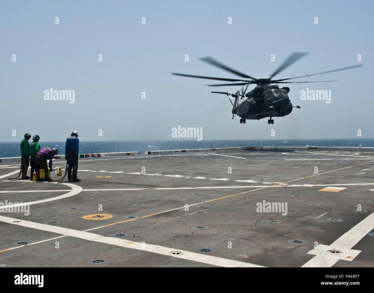 ARABIAN SEA (July 5, 2012) - U.S. Navy Sailors stand-by as an MH-53E Sea Dragon helicopter to land aboard amphibious transport dock ship USS New York (LPD 21). New York is part of the Iwo Jima Amphibious Ready Group with the embarked 24th Marine Expeditionary Unit and is currently deployed in support of maritime security operations and theater security cooperation efforts in the U.S. 5th Fleet area of responsibility. Stock Photo