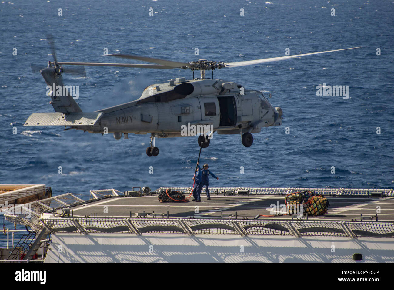 160325-N-VX726-038  PACIFIC OCEAN (March 25, 2016) U.S. Coast Guardsmen assigned to the Legend-class national security cutter USCGC Waesche (WMSL 751) connect a pallet to an MH-60R helicopter assigned to the 'Jaguars' of Helicopter Maritime Strike Squadron (HSM) 60 during a vertical replenishment (VERTREP) with the Arleigh Burke-class guided-missile destroyer USS Lassen (DDG 82) in the eastern Pacific Ocean. Lassen is currently underway in support of Operation Martillo, a joint operation with the U.S. Coast Guard and partner nations within the 4th Fleet area of responsibility. Operation Martil Stock Photo