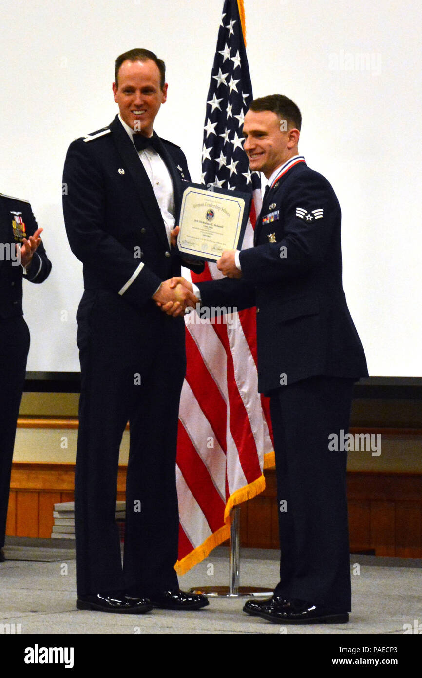 120th Airlift Wing Commander Col. Lee Smith presents an Airman Leadership School diploma to Senior Airman Nicholaus Schwall, March 22, 2016. Schwall was one of 32 students who graduated from ALS Class 16-D at Malmstrom Air Force Base, Mont. (U.S. Air National Guard photo by Senior Master Sgt. Eric Peterson) Stock Photo