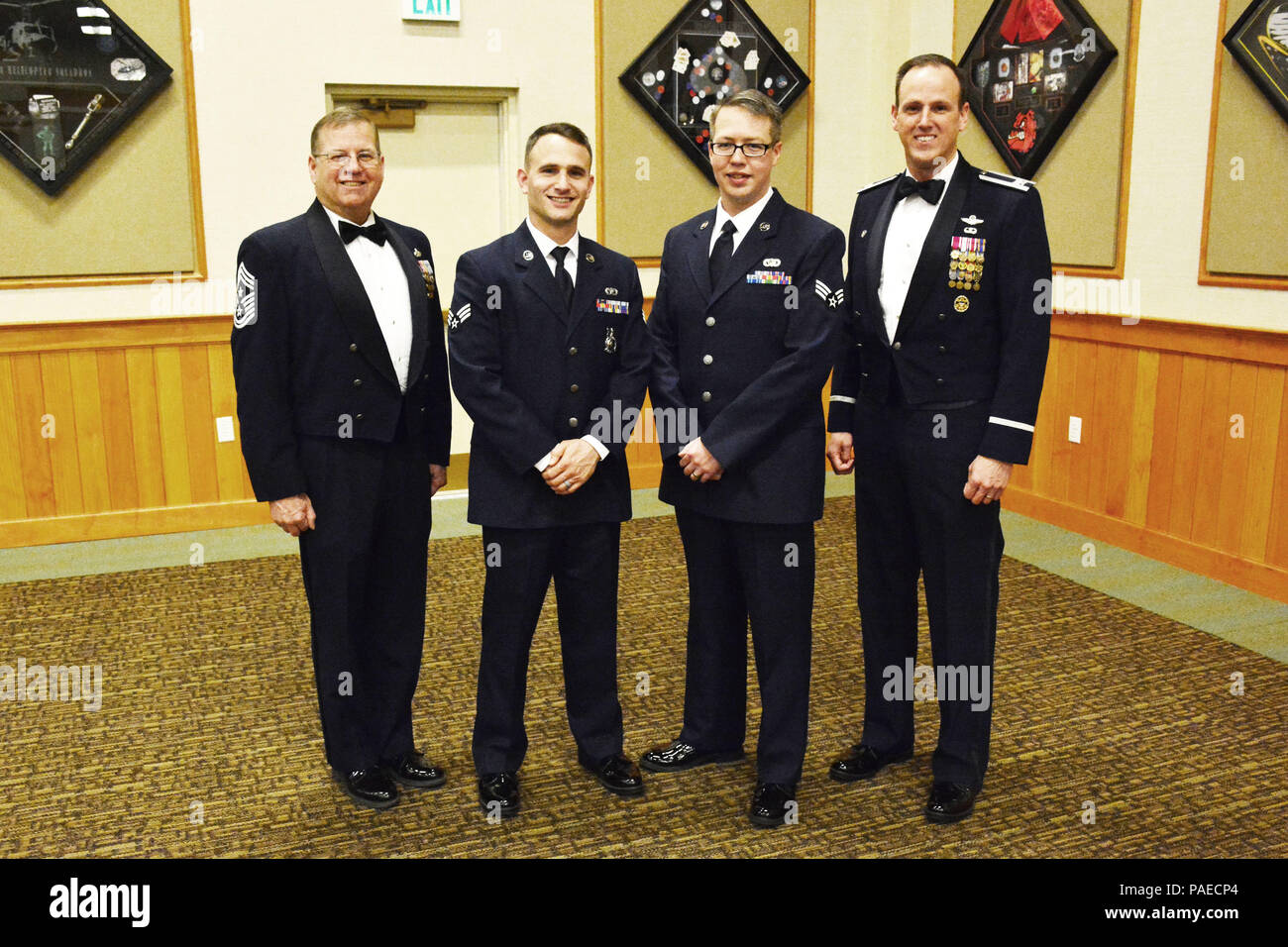 120th Airlift Wing Commander Col. Lee Smith (right) and the 120th Airlift Wing Command Chief, Chief Master Sgt. Steven Lynch (left), stand with the wing’s newest Airman Leadership School graduates (center left to right), Senior Airman Nicholaus Schwall and Senior Airman Nikolas Asmussen, following their graduation ceremony held at Malmstrom Air Force Base, Mont., March 22, 2016. (U.S. Air National Guard photo by Senior Master Sgt. Eric Peterson) Stock Photo