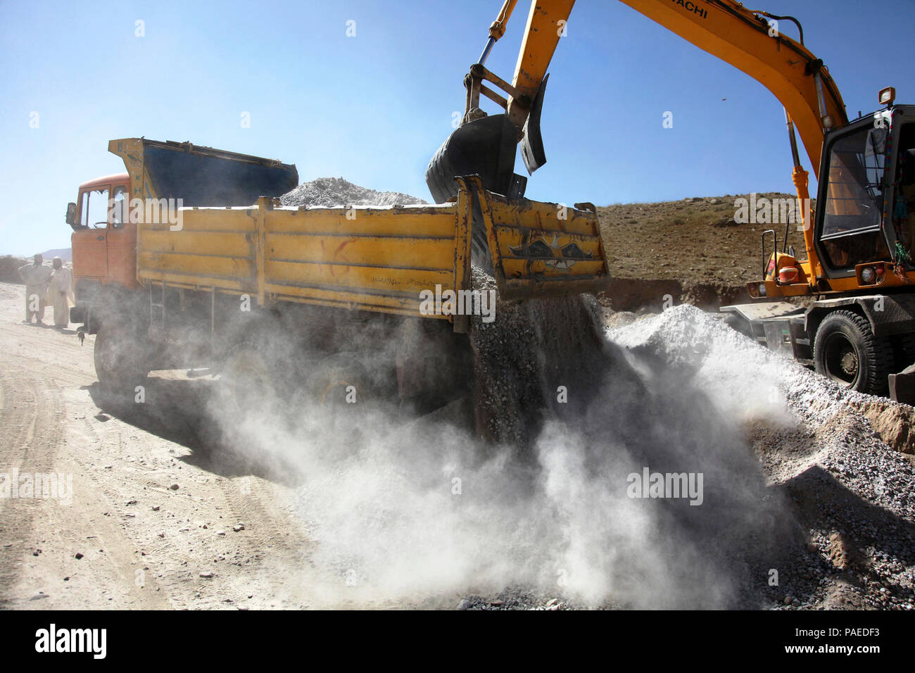 Afghan construction workers work on a road construction project in