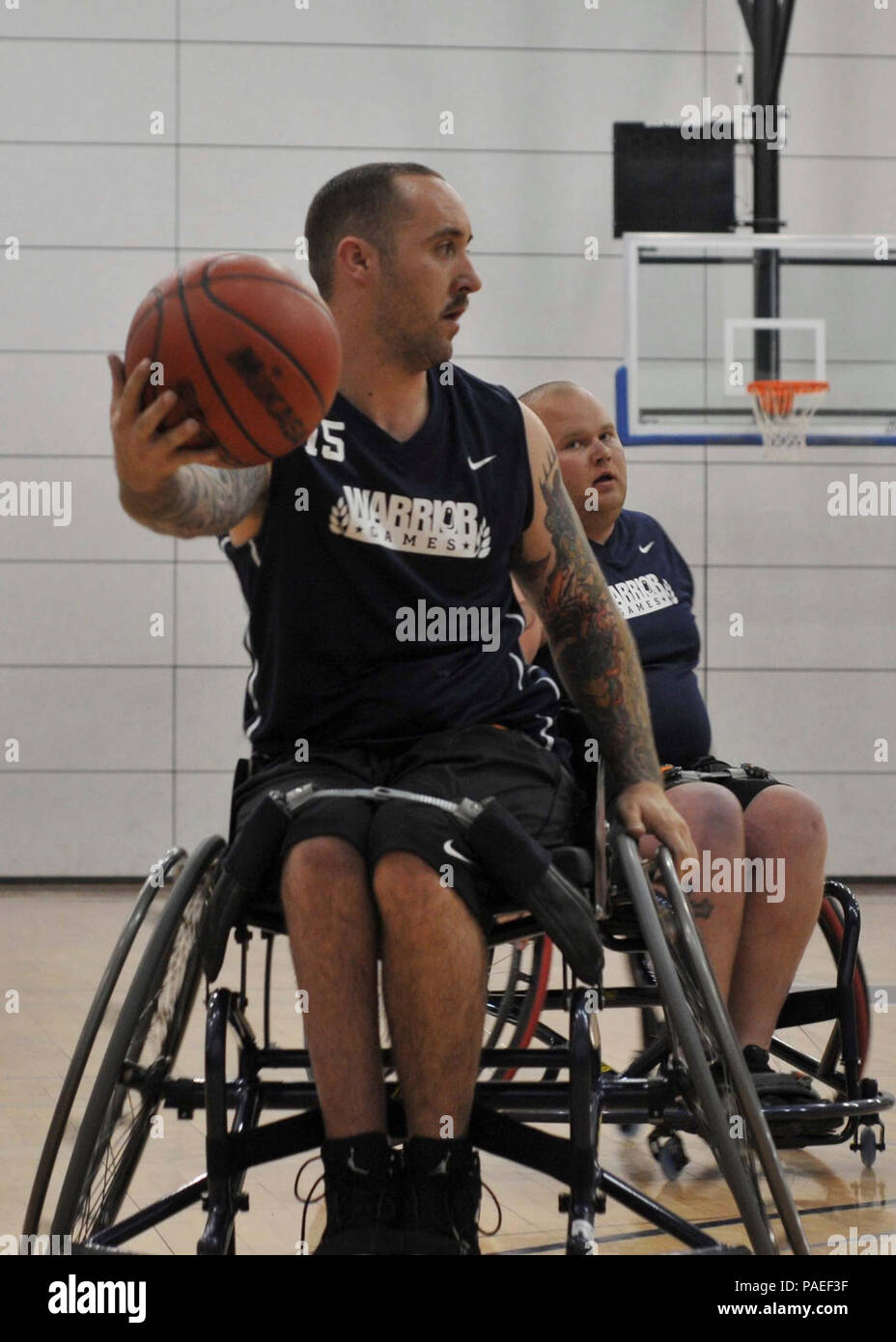 Team Navy/Coast Guard member retired Aviation Electrician's Mate Steven Davis of Turlock, Calif., takes command of the ball in a wheelchair basketball game against Team Air Force during the 2013 Warrior Games May 14. The Warrior Games includes competitions in archery, cycling, seated volleyball, shooting, swimming, track and field, and wheelchair basketball. The goal of the Warrior Games is not necessarily to identify the most skilled athletes, but rather to demonstrate the incredible potential of wounded warriors through competitive sports. More than 200 wounded, ill, or injured service membe Stock Photo