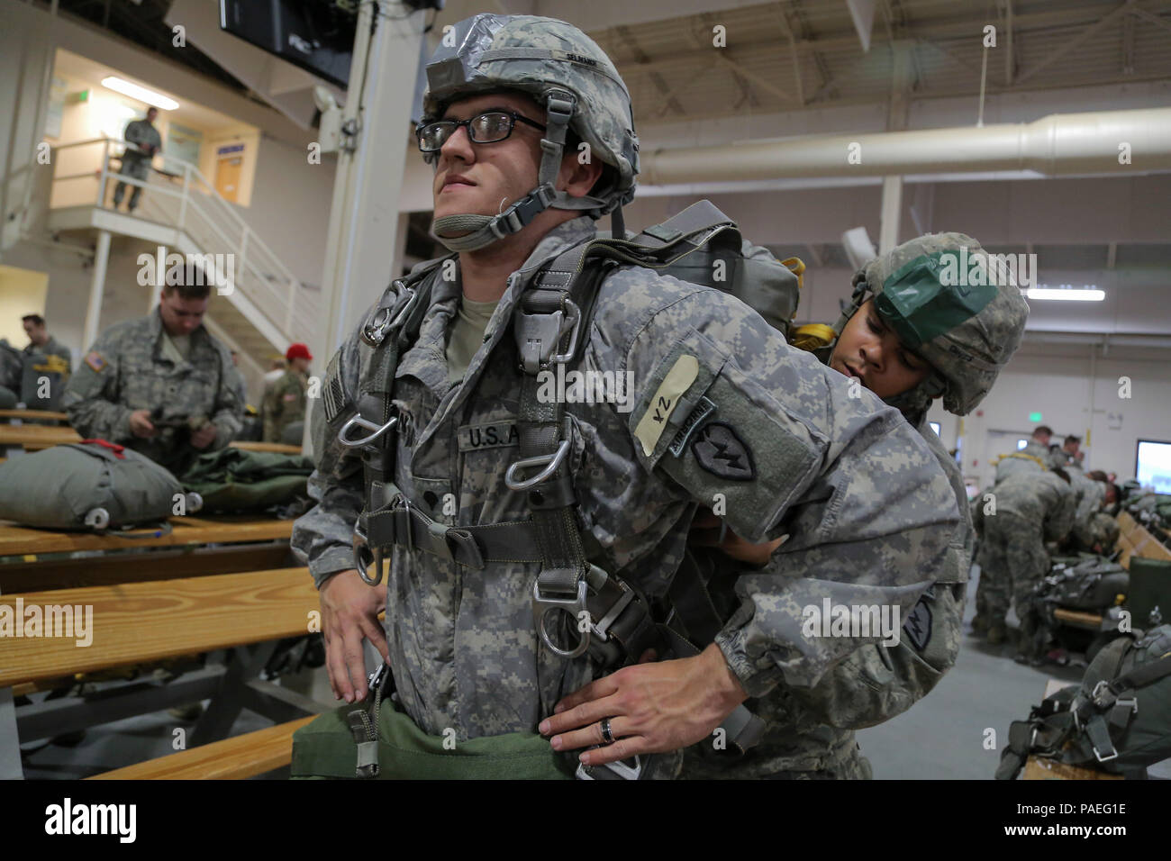 U.S. Army Pfc. Donovan Davis assists Spc. Andre Selivanov, front, don ...