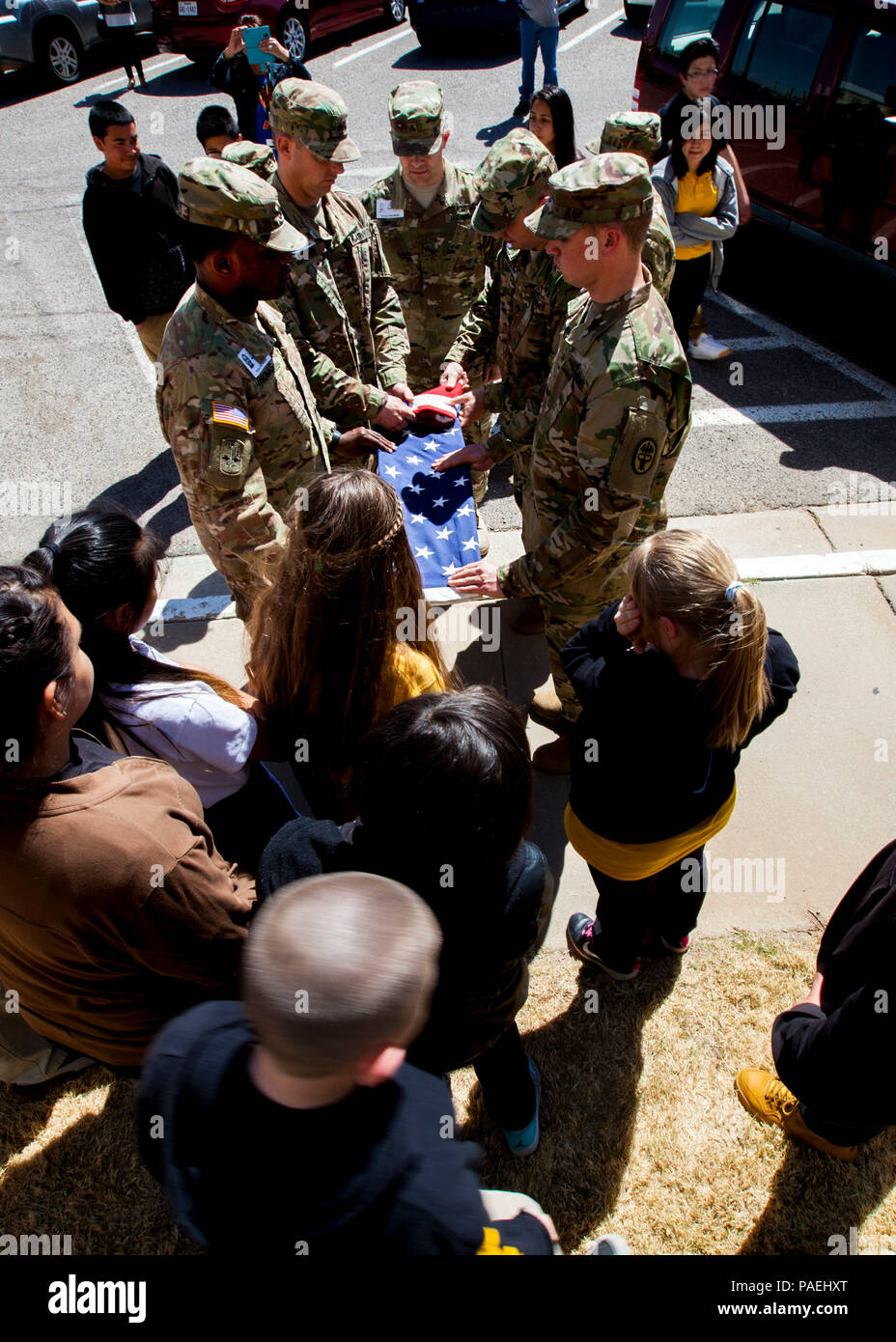 Students from Terrace Hills Middle School watch as Soldiers with William Beaumont Army Medical Center’s Color Guard detail fold the U.S. flag at Terrace Hills Middle School during both WBAMC and the school’s first Partners in Education (PIE) partnership event, March 17. Soldiers instructed students on proper flag raising / lowering and folding procedures during the event. The PIE program allows Soldiers to become mentors and instructors to local students in the community. Stock Photo