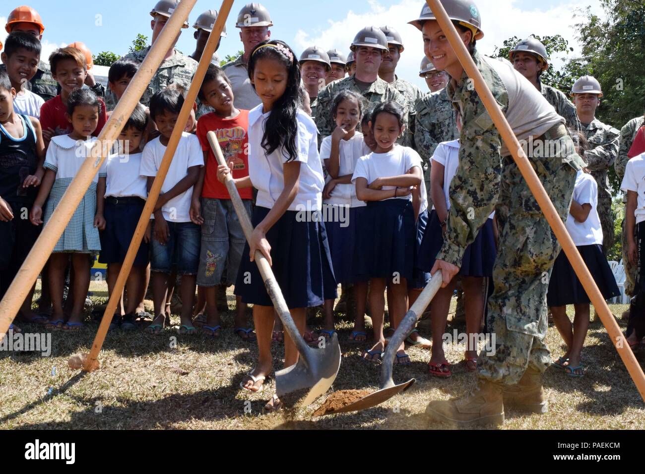 160321-N-NO181-003  PALAWAN, Philippines (Mar. 21, 2016) - Utilitiesman 3rd Class Victoria Vento, assigned to Naval Mobile Construction Battalion (NMCB) 4 helps a student at the Napsan Elementary School in Palawan, Philippines bury a time capsule before beginning a construction project, Mar. 21. (U.S. Navy photo by Construction Electrician Constructionman Samantha Leal/Released) Stock Photo