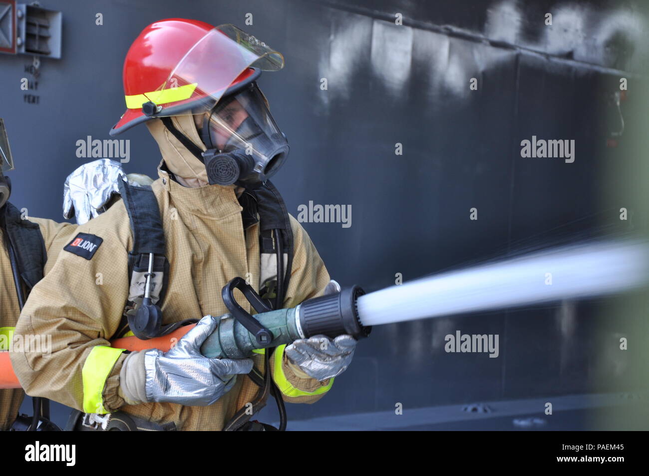 Pvt. First Class Douglas Baggett, a watercraft operator with the 1099th Transportation Detachment assigned to the SP4 James A. Loux, Logistics Support Vehicle-6, uses a fire hose to drench a door during a fire drill while out to sea in the Persian Gulf, March 1, 2016.    All Army mariners receive firefighting training during their Advanced Individual Training. Stock Photo