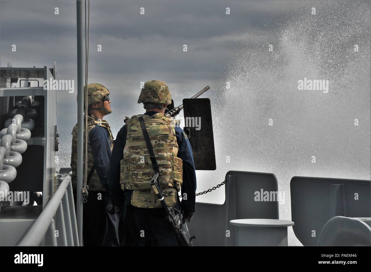 Army mariners with the 1099th Transportation Detachment assigned to the SP4 James A. Loux, Logistics Support Vehicle-6, are splashed by a wave while conducting a battle station drill during a mission in the Persian Gulf, March 3, 2016.    All members of the vessel are trained to use a variety of small arms and crew-served weapons in case the boat is attacked. Stock Photo