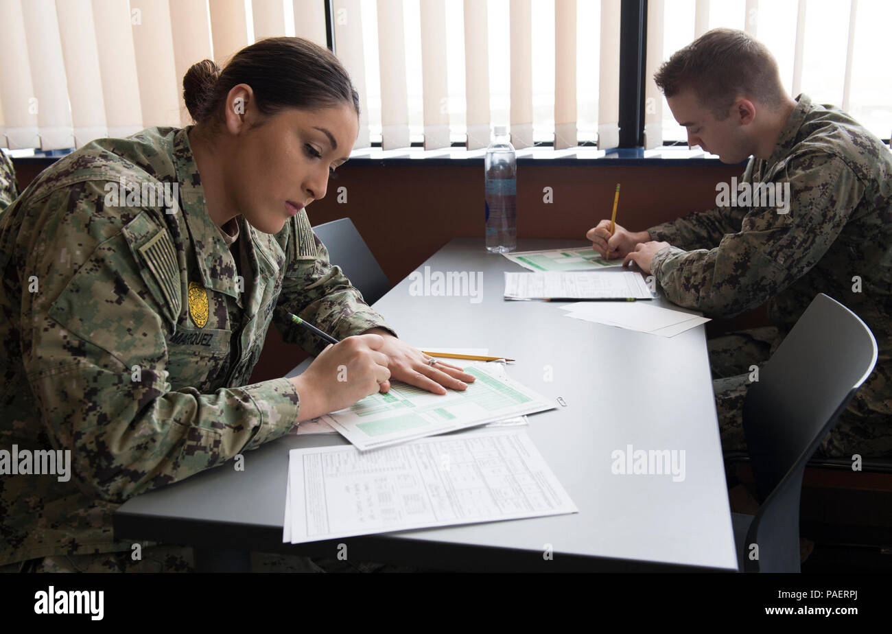 SUPPORT FACILITY DEVESELU, Romania (March 8, 2018) Naval Support Facility (NSF) Deveselu Sailors Master-at-Arms 3rd Class (MA3) Alicia Marquez, left, a Depue, Illinois native and MA3 Nicholas Ledbetter, a Clarksville, Arizona native, take the Navywide E-5 advancement exam. NSF Deveselu and Aegis Ashore Missile Defense System Romania are co-located with the Romanian 99th Military Base and play a key role in ballistic missile defense in Eastern Europe. Photo has been edited for security purposes by blurring test pages. Stock Photo