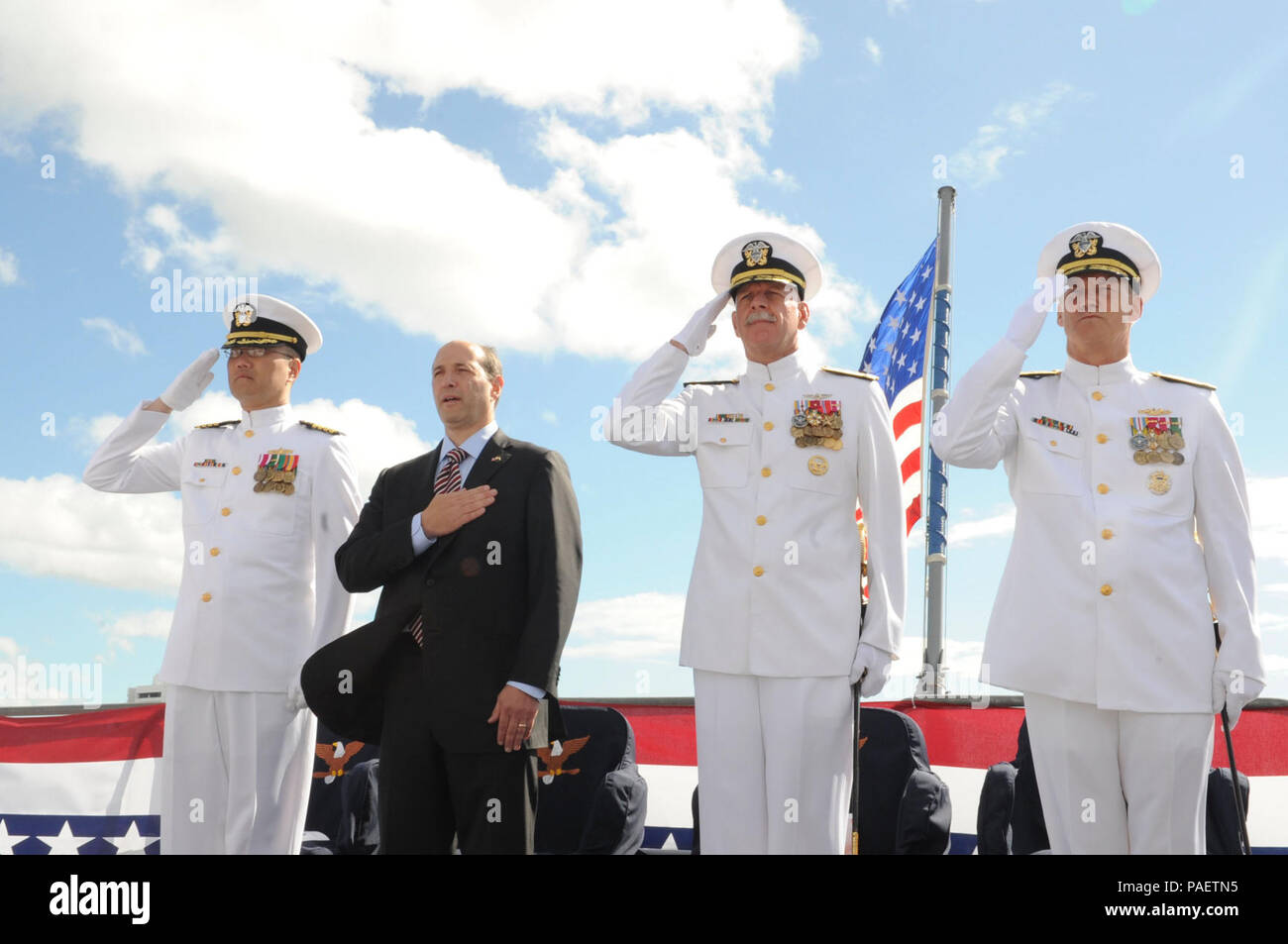 CAIRNS, Australia (July 31, 2013) Vice Adm. Robert L. Thomas Jr., right, salutes after taking command of the U.S. 7th Fleet alongside departing 7th Fleet Commander Vice Adm. Scott H. Swift, Jeffrey Bleich, U.S. Ambassador to Australia and Capt. John Shimotsu, 7th Fleet Chaplain, during a change of command ceremony on board the flagship USS Blue Ridge (LCC 19) in Cairns, Australia. Blue Ridge and embarked 7th Fleet staff are currently on patrol operating forward, building maritime partnerships and conducting security and stability operations. Stock Photo