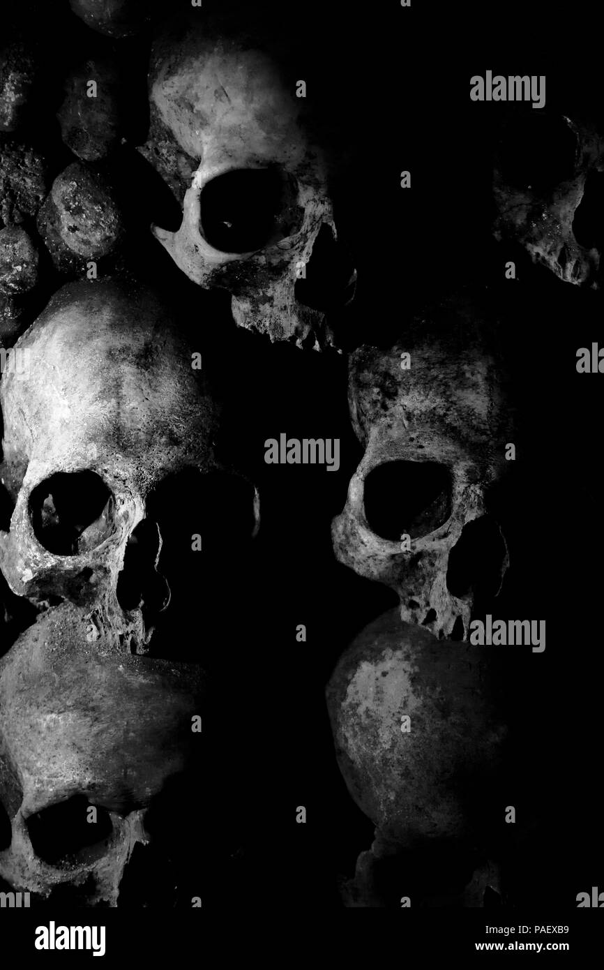 A Low-Key photo of some skulls in the Catacombs under Paris. (France Stock  Photo - Alamy, image size:866x1390