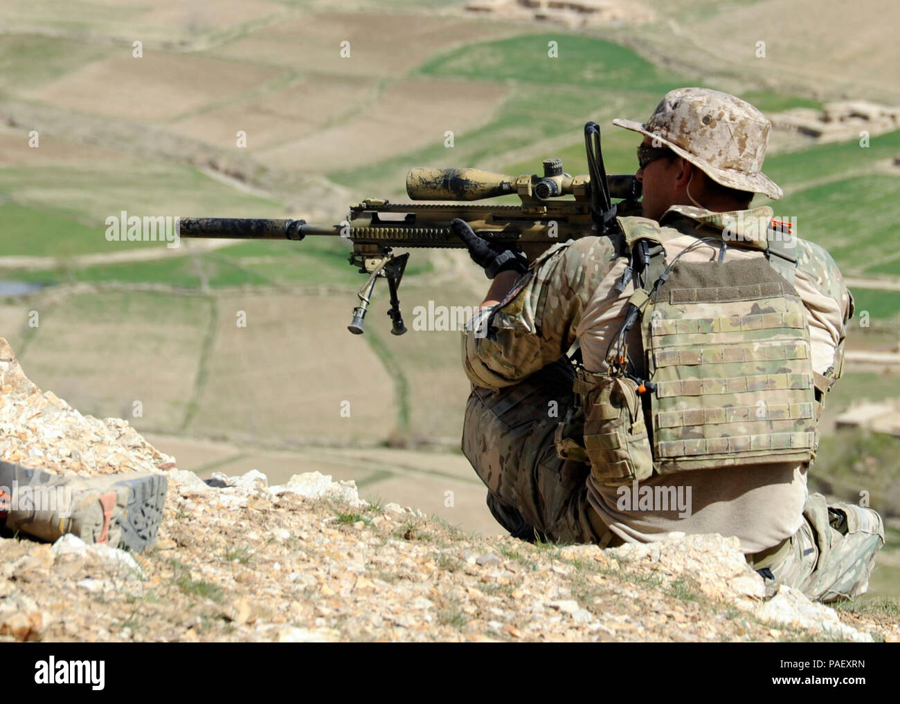 A coalition special operations forces member fires his sniper rifle from a hilltop during a firefight near Nawa Garay village, Kajran district, Daykundi province, Afghanistan, April 3. Coalition SOF partners with the 8th Commando Kandak to conduct operations throughout Daykundi, Uruzgan and Zabul provinces. Stock Photo