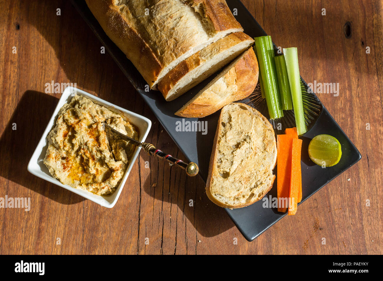 Hummus with sourdough bread on wooden jarrah board Stock Photo Alamy