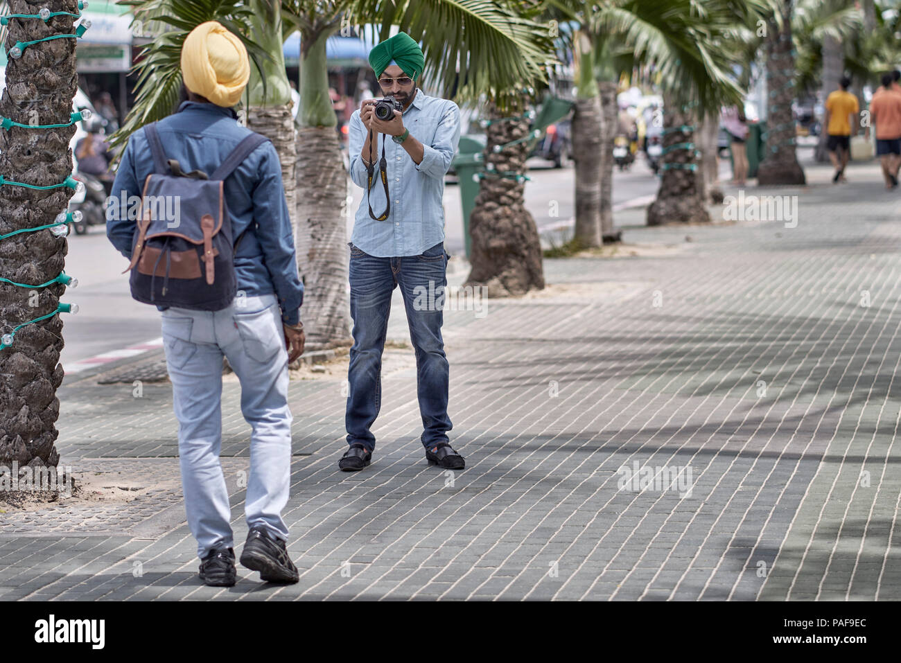 Indian Sikh man taking a photograph of his Sikh friend on the street Stock Photo