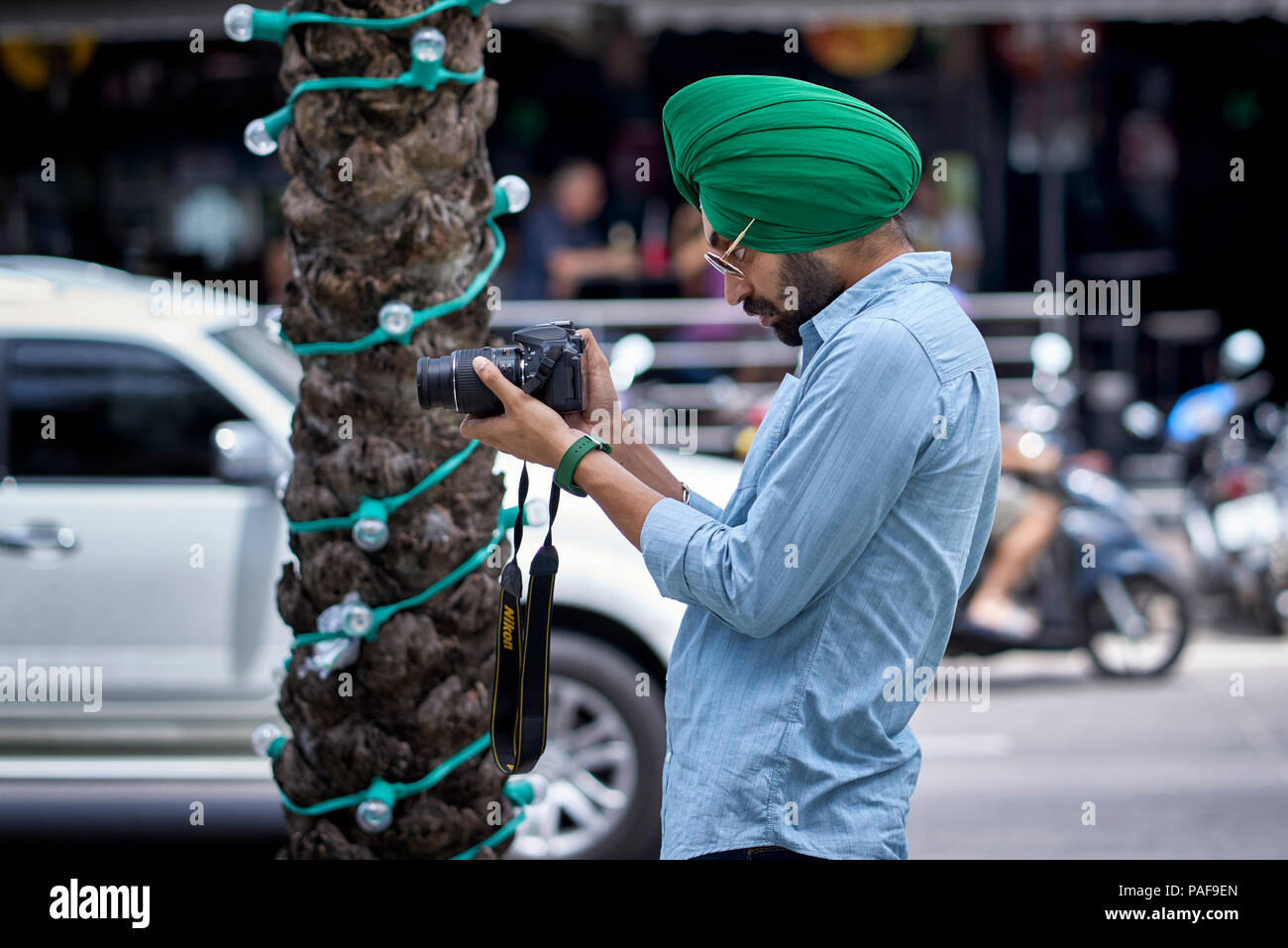 Indian Sikh man taking a photograph using the camera LCD screen Stock Photo