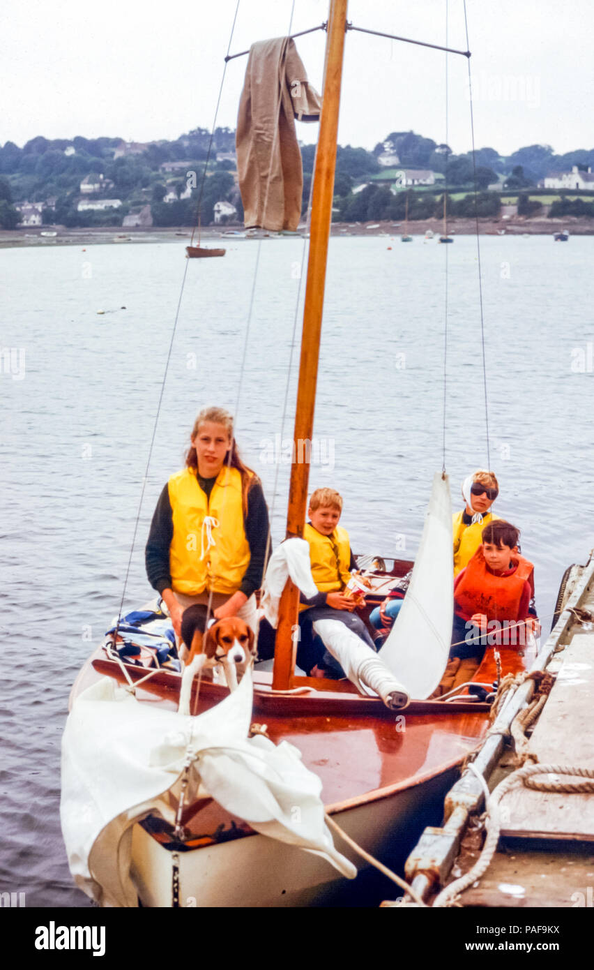 Family of a mother and three children wearing life vests in small