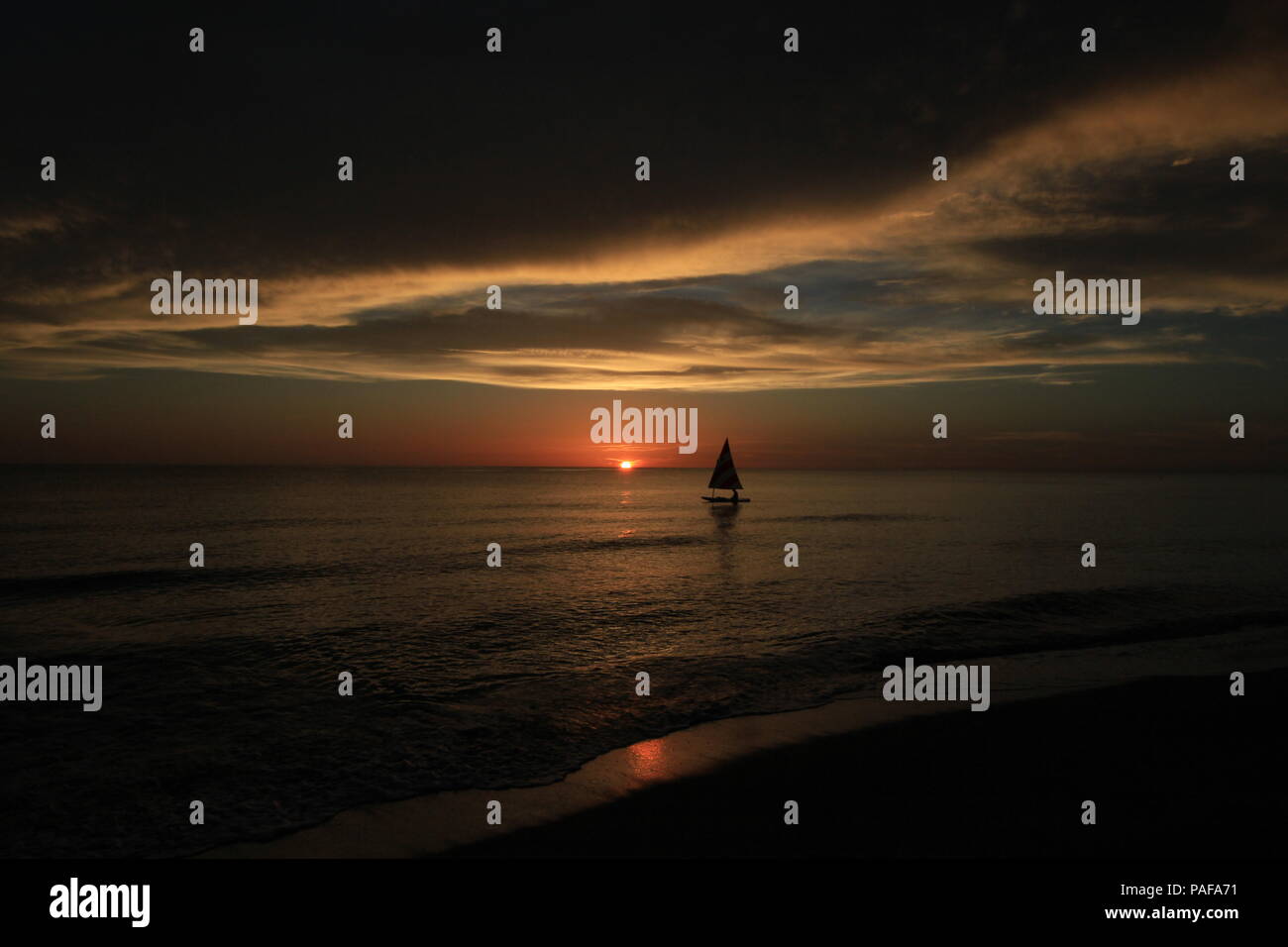 Sailboat (Sunfish) at sunset off Captiva Island, Florida, United States. Stock Photo