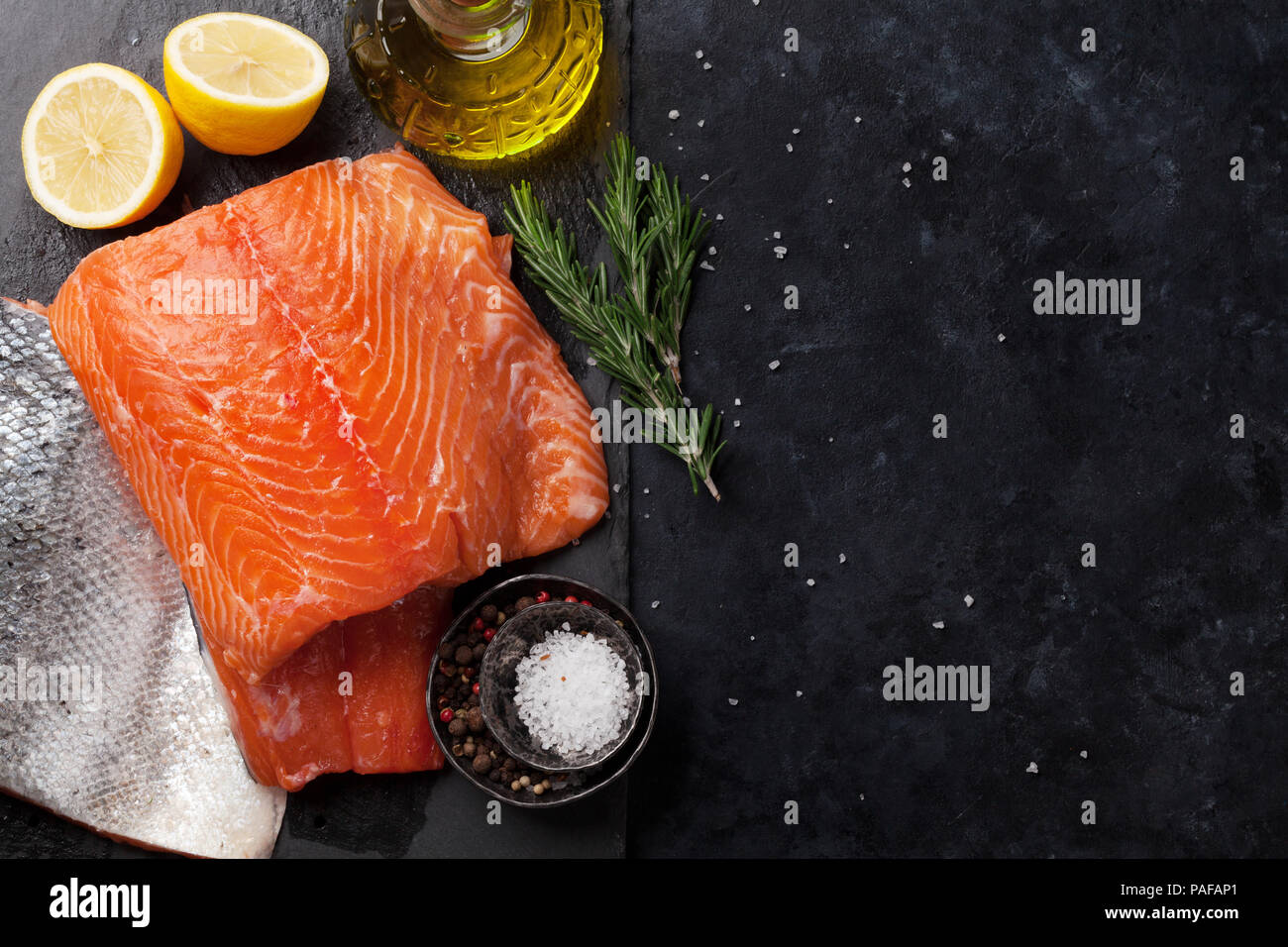 Raw salmon fish fillet with spices cooking on cutting board. Top view ...