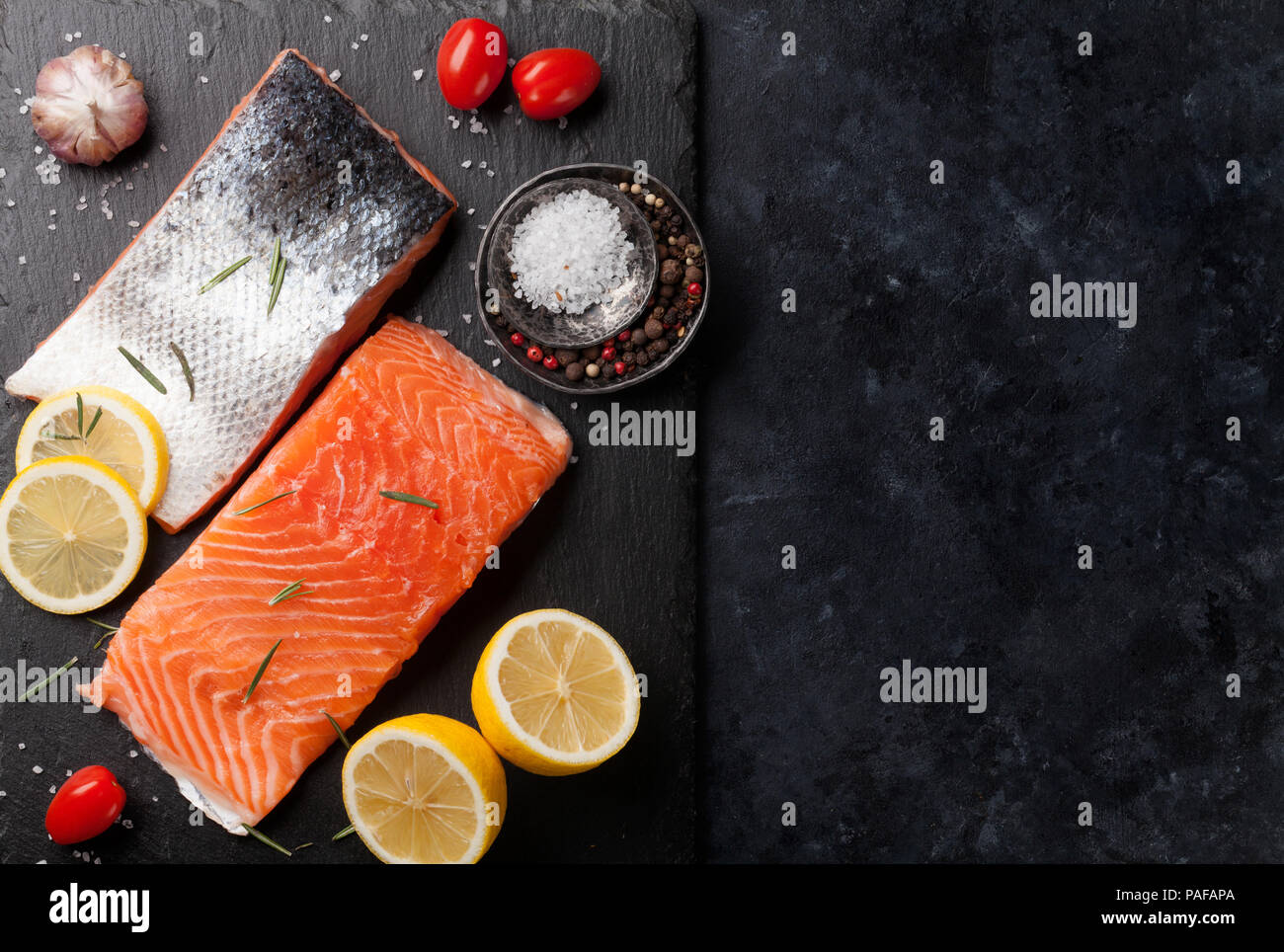 Raw salmon fish fillet with spices cooking on cutting board. Top view ...
