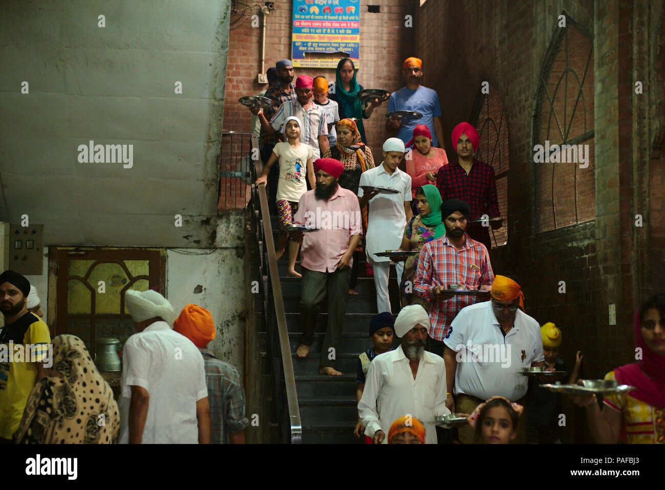 The langar at Golden temple at Amritsar, where 60000 free meals are served everyday, and that mostly relies on volunteers to run it. Stock Photo