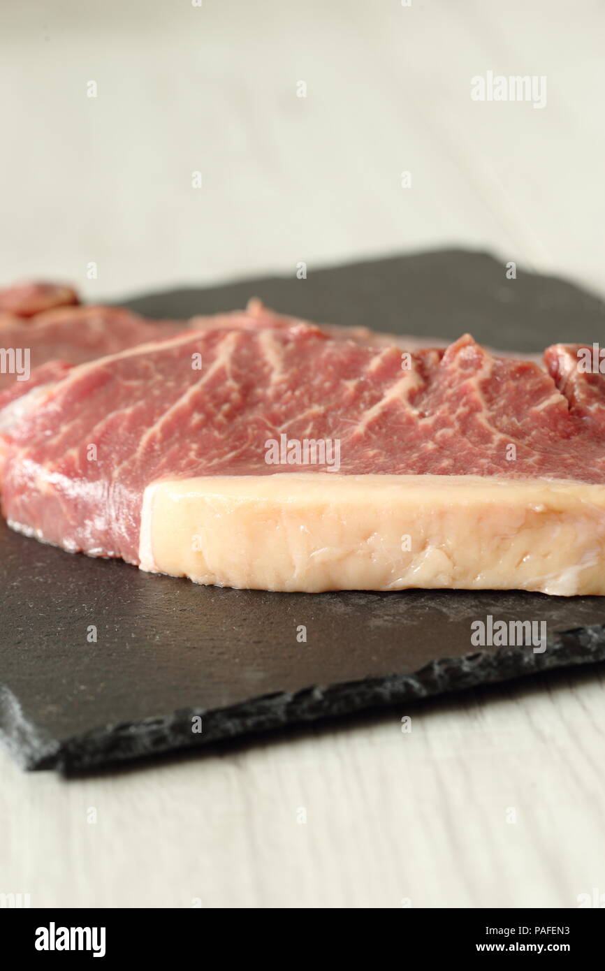 Sirloin steak beef joints on a slate cutting board on a grey wood background Stock Photo Alamy
