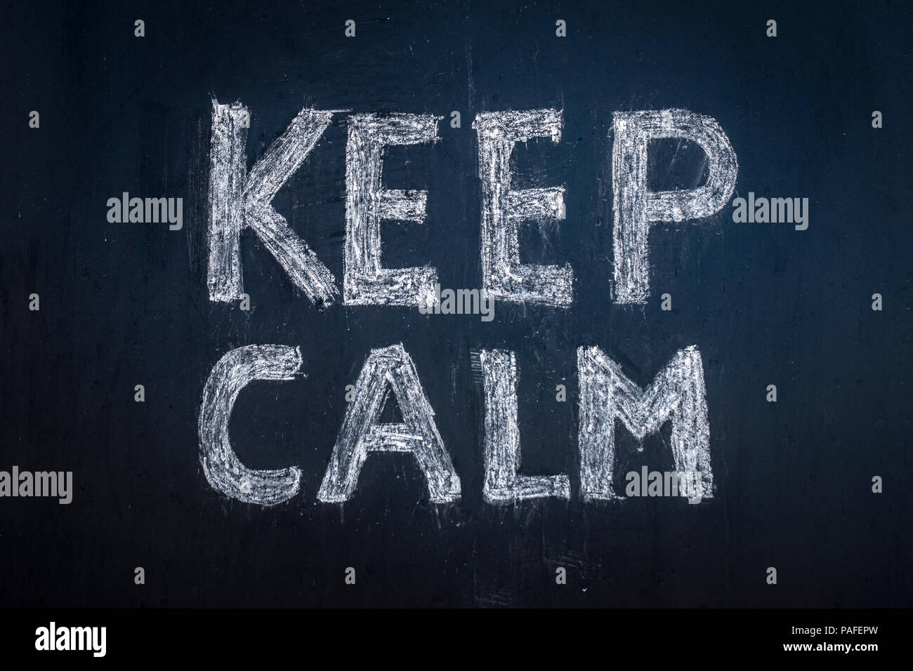 Text Keep calm written in chalk on a black board. Stock Photo