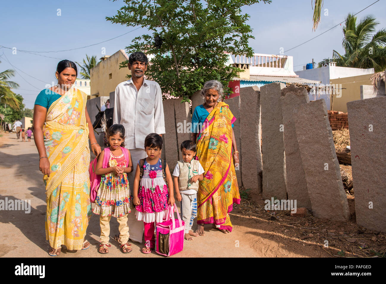 PUTTAPARTHI, ANDHRA PRADESH, INDIA - JULY 9, 2017: Indian family in a village street. Copy space for text Stock Photo