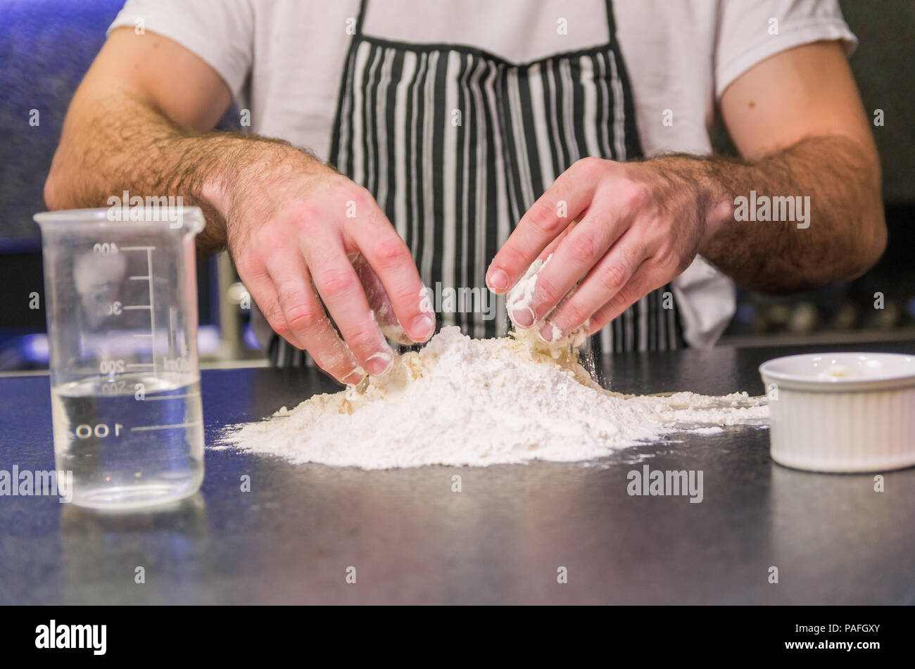 Man preparing pizza dough on black granite table Stock Photo