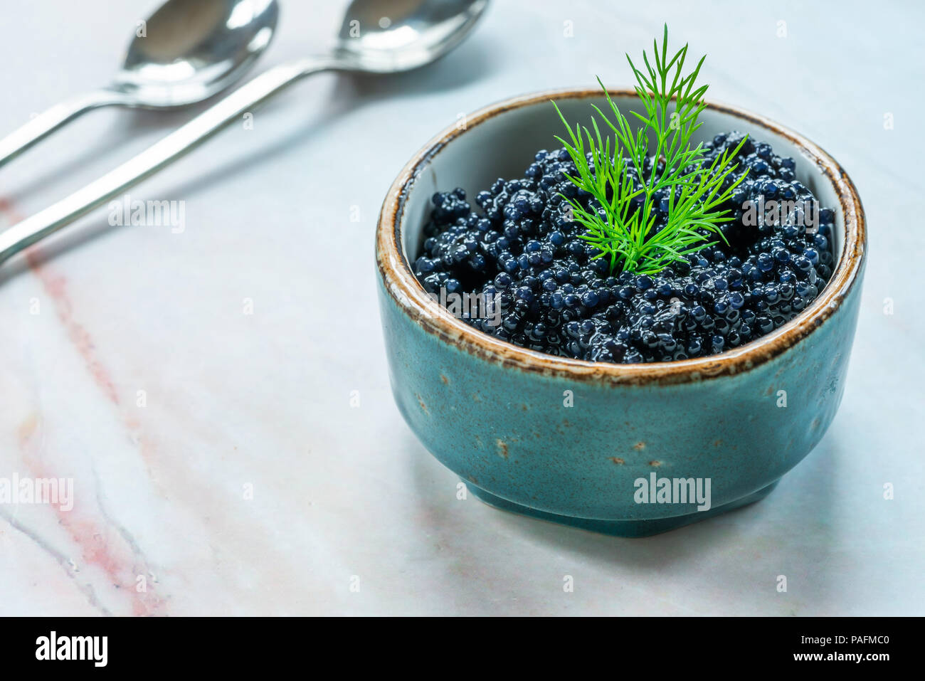 Black lumpfish caviar in a small pot Stock Photo