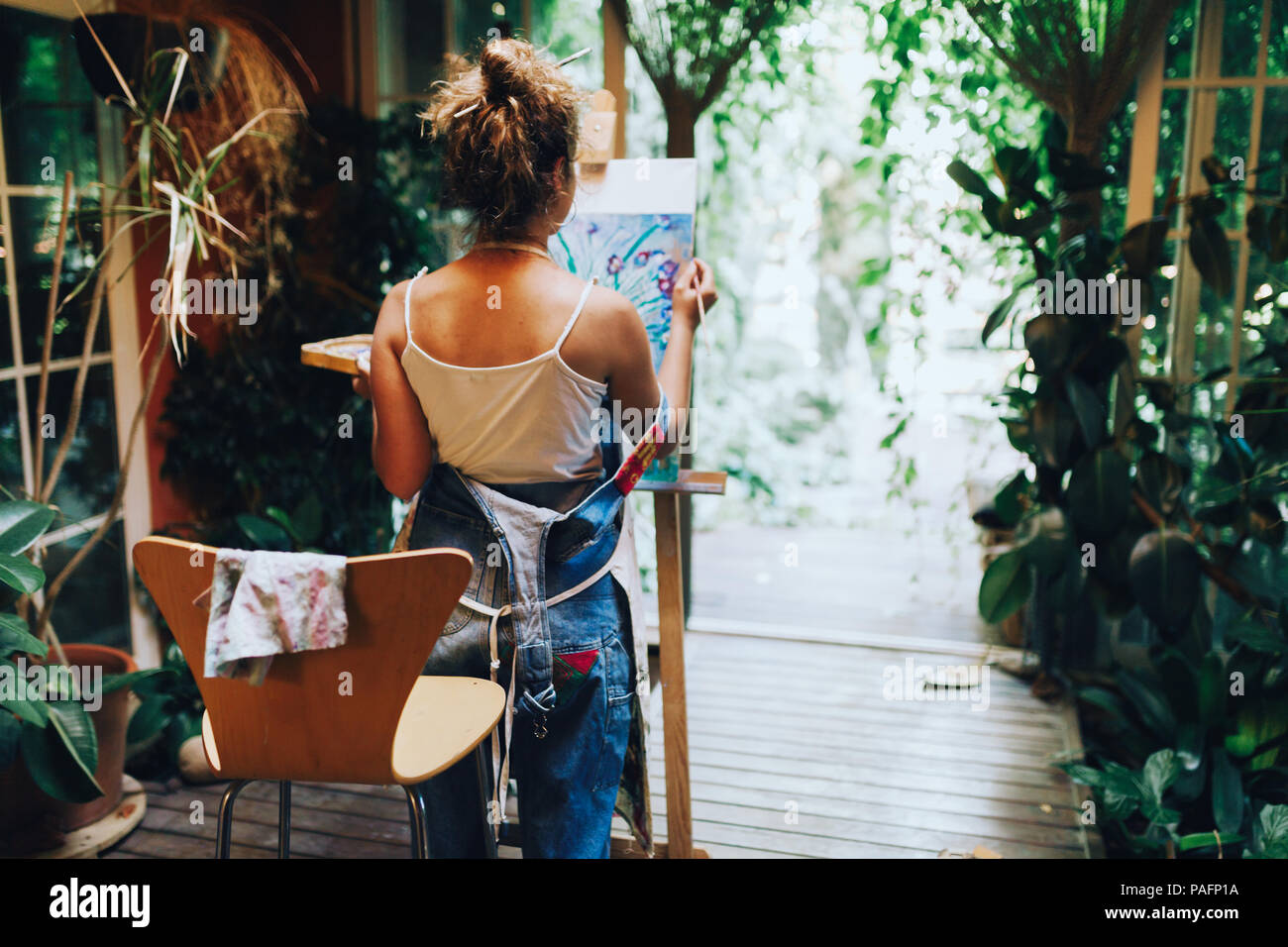 Indoor shot of professional female artist painting on canvas in studio
