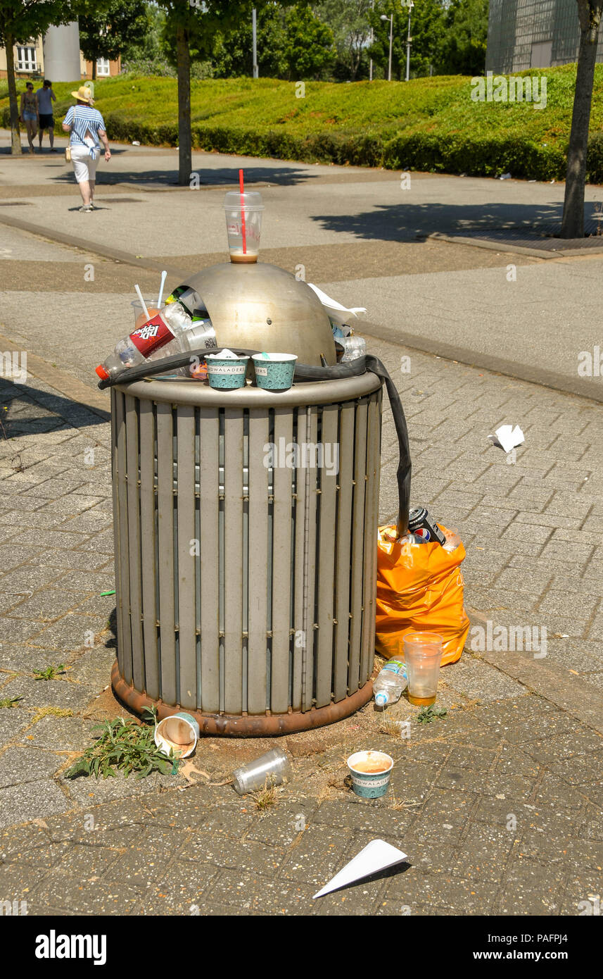 Waste bin overflowing with rubbish on a city street Stock Photo