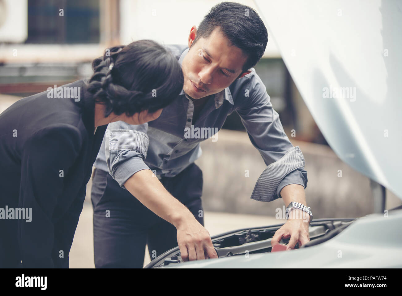 Businessmen help businesswomen check and repair broken cars Stock Photo ...