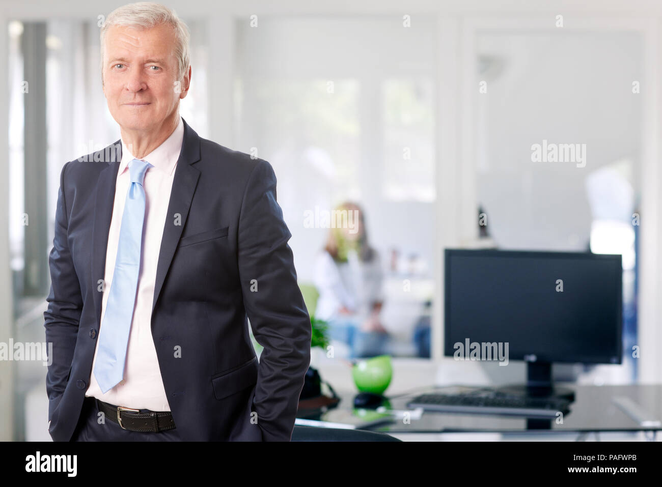 A senior managing director businessman standing at the office while