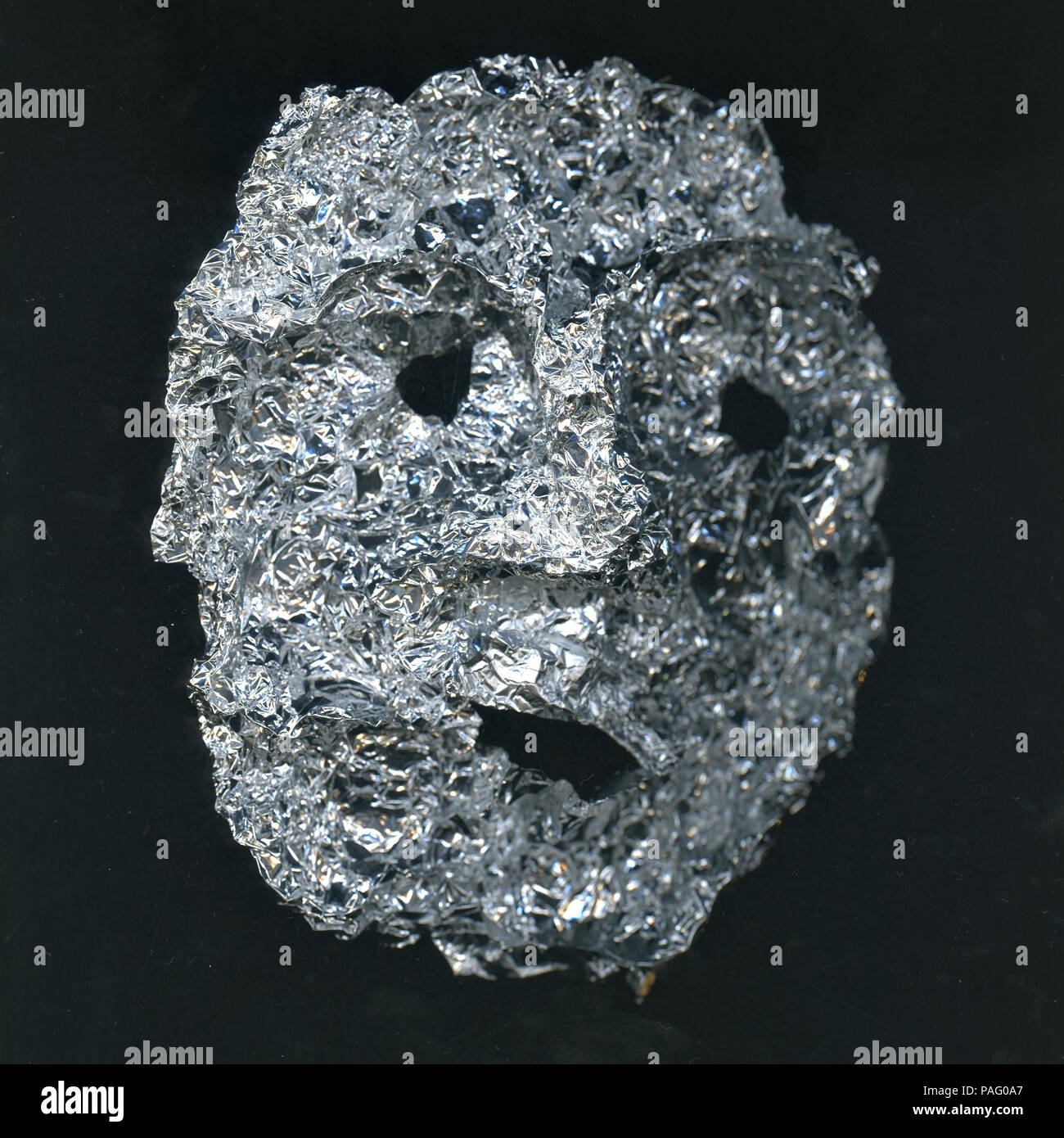 Mask of human face made from silver foil. Concept of ugly man Stock Photo